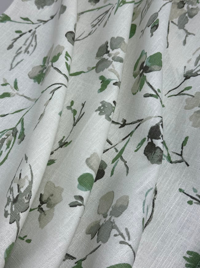 Floral patterned fabric with green and grey flowers on a white background